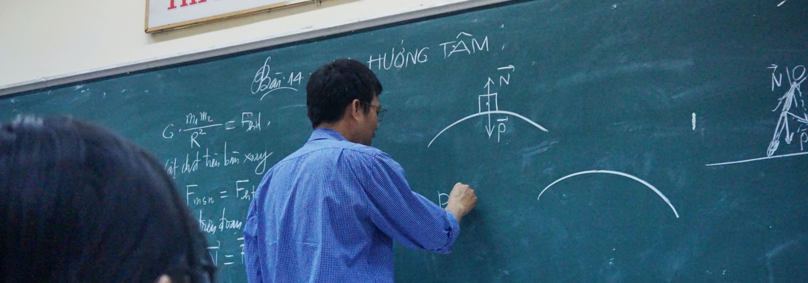 professor writing on chalkboard